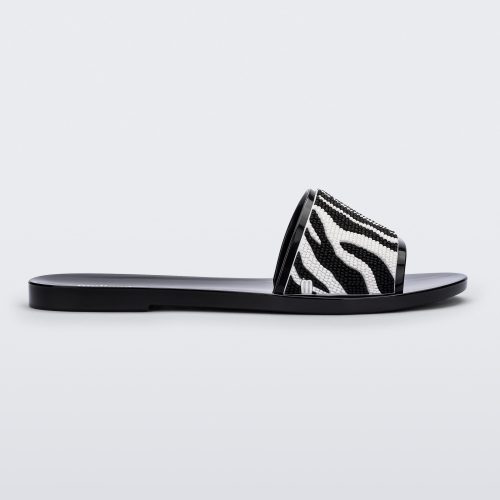 Side view of a black/white Melissa Savage slide with a zebra print on the strap.