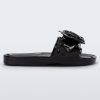 Side view of a black Melissa Spikes Beach slide with a flower detail and spikes on the front strap.