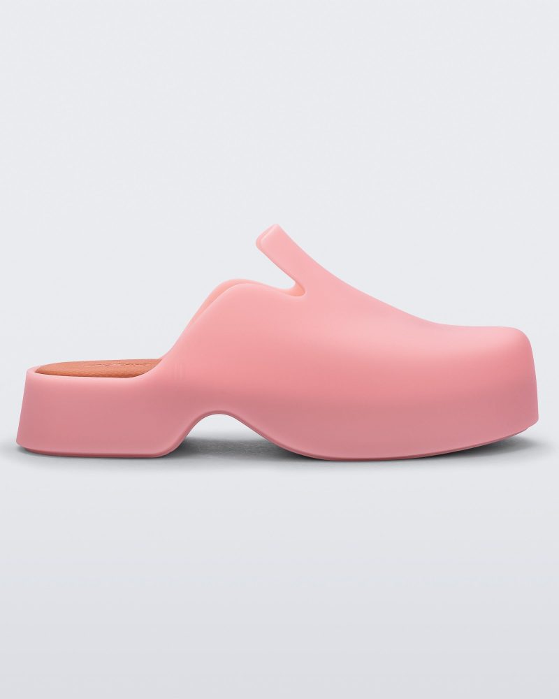 Side view of a pink Melissa Zoe mule and orange insoles.