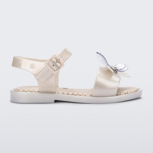 Side view of a metallic white Mini Melissa Mar Bugs sandal with a metallic white base, an ankle strap, front strap with a bug detail buckle on the front and a honey comb pattern sole.