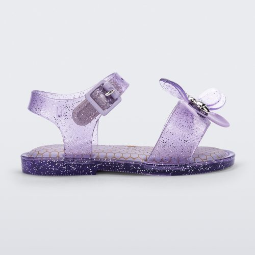 Side view of a lilac glitter Mini Melissa Mar Bugs sandal with a honeycomb pattern insole and a lilac bug detail with a silver buckle on the front.