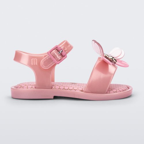 Side view of a pearly pink Mini Melissa Mar Bugs sandal with a honeycomb pattern insole and a pink bug detail with a gold buckle on the front.