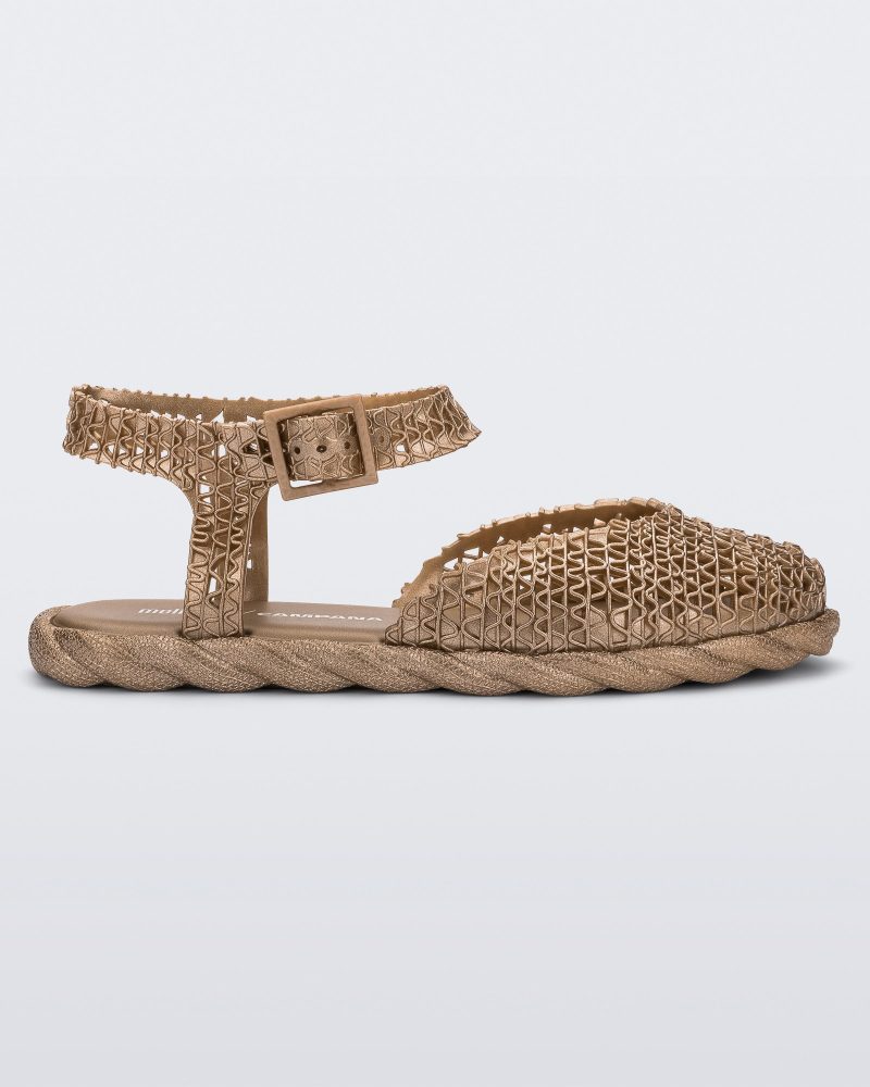 Side view of a gold Melissa Papel Espadrille Campana sandal with braided sole detail and ankle strap