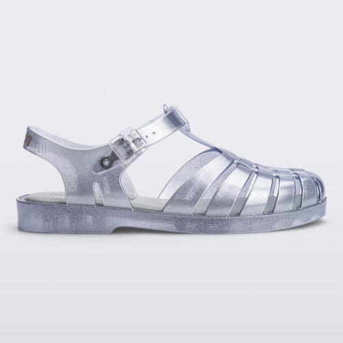 Side view of a silver Melissa Possession sandal with a closed toe front weft design connected to a top strap with a buckle.