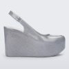 Side view of a clear glitter Melissa Groovy wedge platform slingback heel with peep toe.