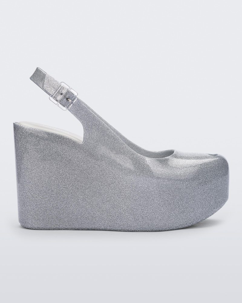 Side view of a clear glitter Melissa Groovy wedge platform slingback heel with peep toe.