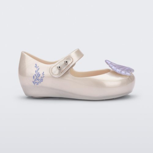 Side view of a pearly white Mini Melissa Ultragirl + Disney Little Mermaid flat with a pearly blue shell on top