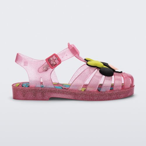 Side view of a clear pink glitter Mini Melissa Possession + Disney 100 sandal with Mickey on one foot and Minnie on another foot.