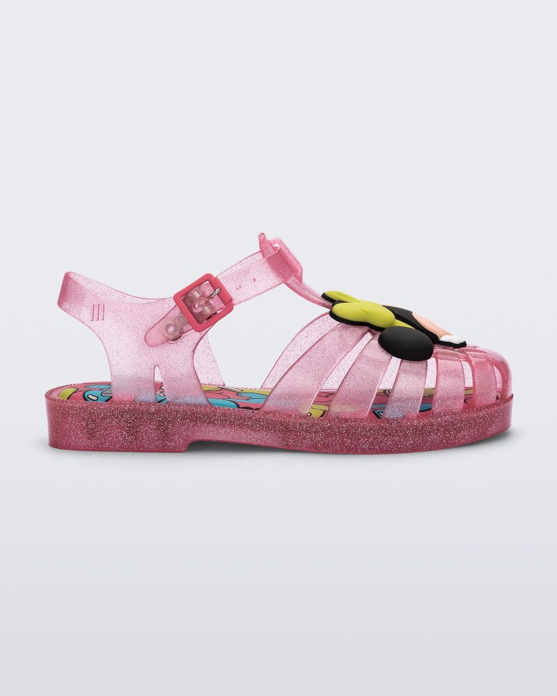 Side view of a clear pink glitter Mini Melissa Possession + Disney 100 sandal with Mickey on one foot and Minnie on another foot.