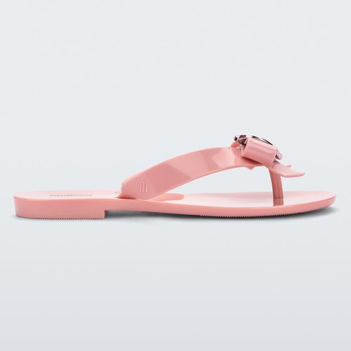 Side view of a pink Melissa Harmonic Heart flip flop with a pink bow and metallic pink heart detail on the straps