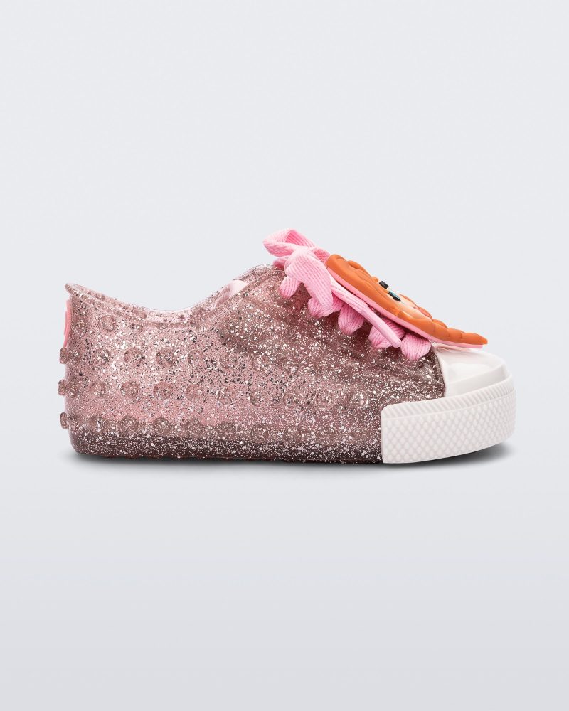 Side view of a baby glitter pink Melissa Polibolha sneakers with a white toe top and Disney Frozen's Anna.