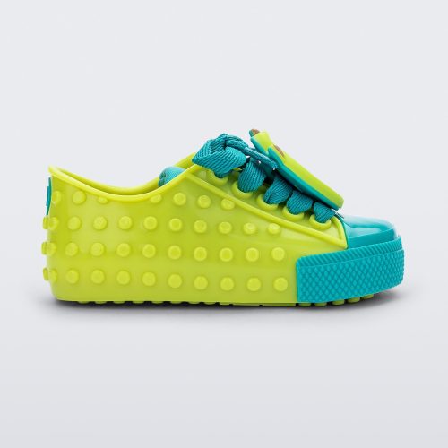 Side view of a baby green Melissa Polibolha sneakers with a blue toe top and Disney Monsters Inc Mike.