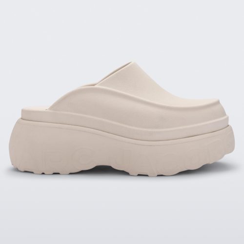 Side view of a beige Melissa Clog with the Marc Jacob's logo across the sole.