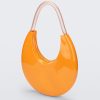 An angled front view of a orange/beige Melissa Moon Bag with a crescent shaped orange bag base and a clear beige top strap.