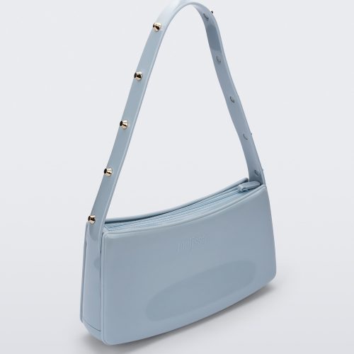 Angled view of the blue Melissa Baguete Studs bag with a short studded strap.