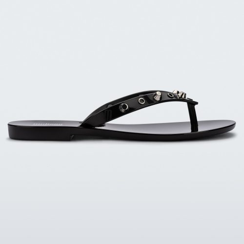 Side view of a black Melissa Harmonic Studs flip flop with gold studs on the upper.