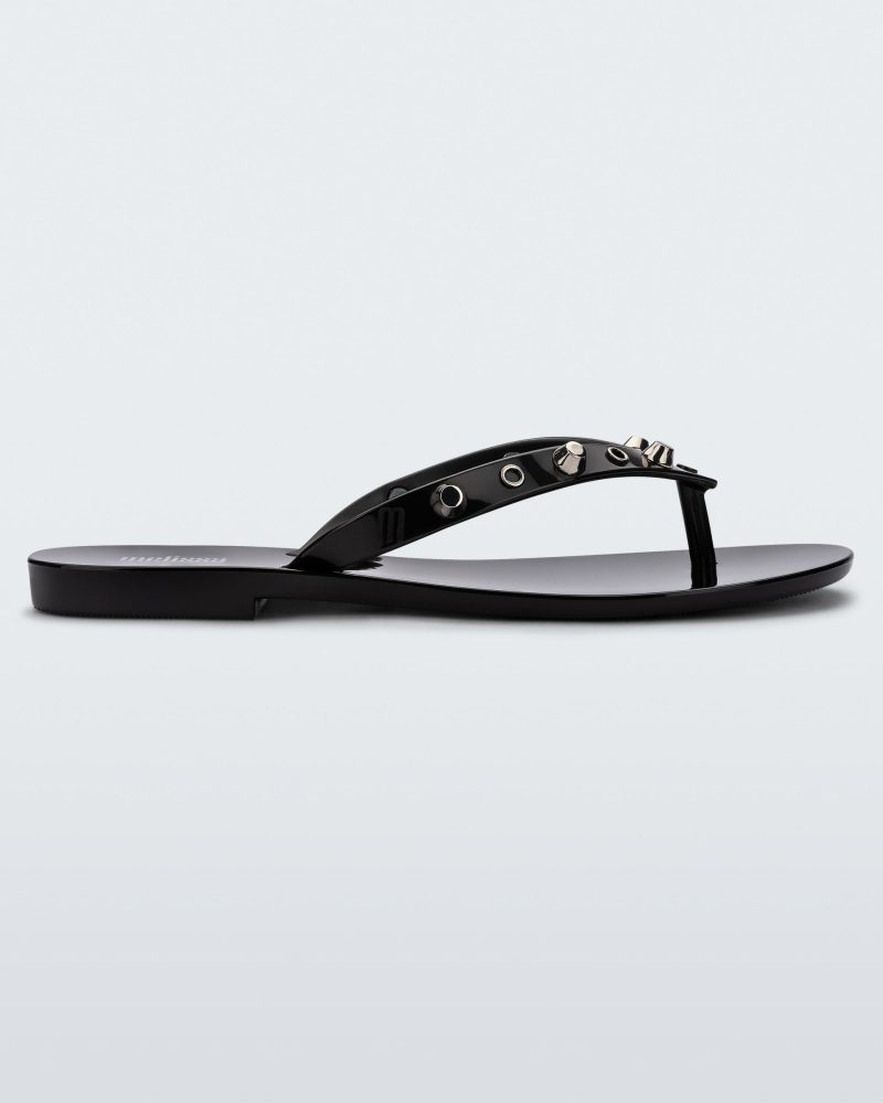 Side view of a black Melissa Harmonic Studs flip flop with gold studs on the upper.