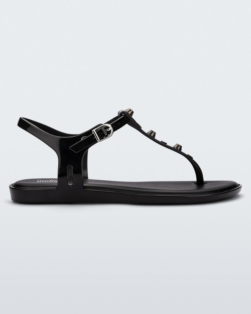 Side view of a black Melissa Solar studs sandal with gold studded t-strap and gold buckle.