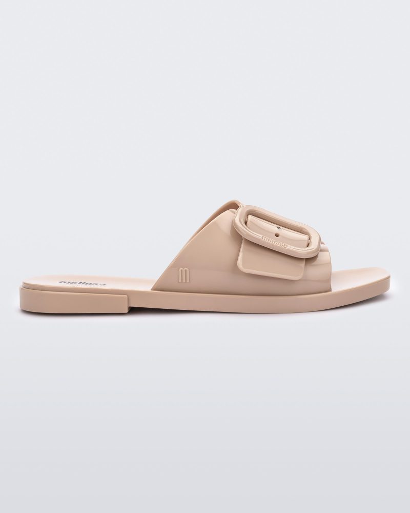 Side view of a Beige Melissa Lislie slide with a buckle detail on the top strap.