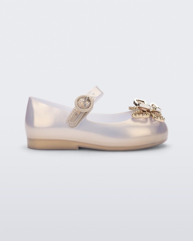 Side view of a pearly gold Mini Melissa Sweet Love Butterfly flat with a top strap and a gold butterfly detail on the toe