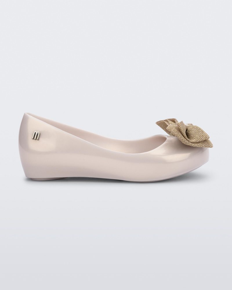 Side view of a pearly beige Ultragirl Sweet kids ballerina flat with bow