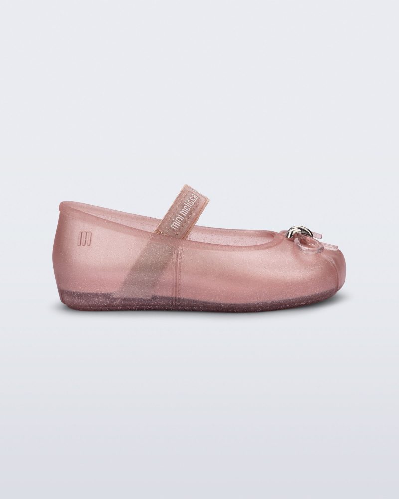 Side view of a pearly pink Sophie baby ballerina flat with bow