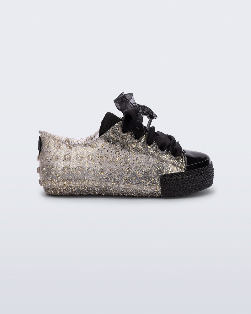 Side view of a clear glitter Polibolha baby sneaker with black laces.