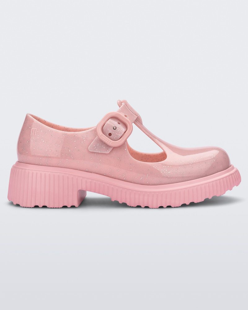 Side view of a Pink Mini Melissa Jackie loafer with a pink glitter base, two cut outs, a pink buckle detail strap and pink sole.