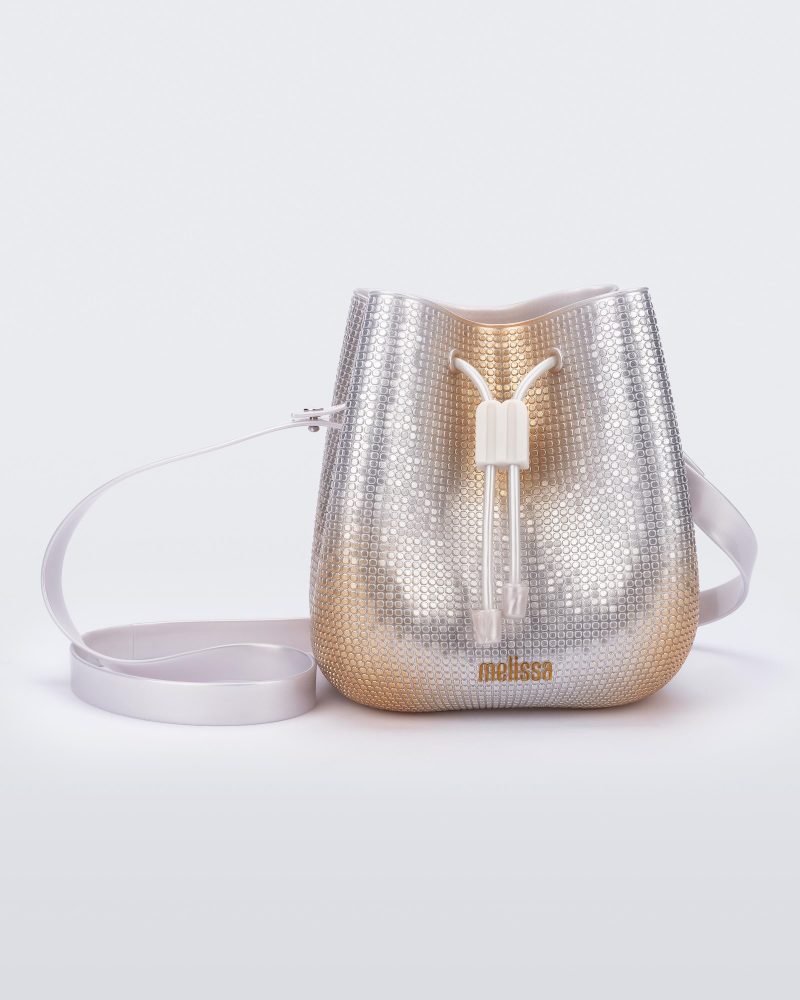 Front view of a silver/gold Lux bucket bag with drawstring and strap