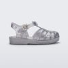 Side view of a Mini Melissa Possession baby sandal in glitter clear with velcro buckle closure on the ankle strap