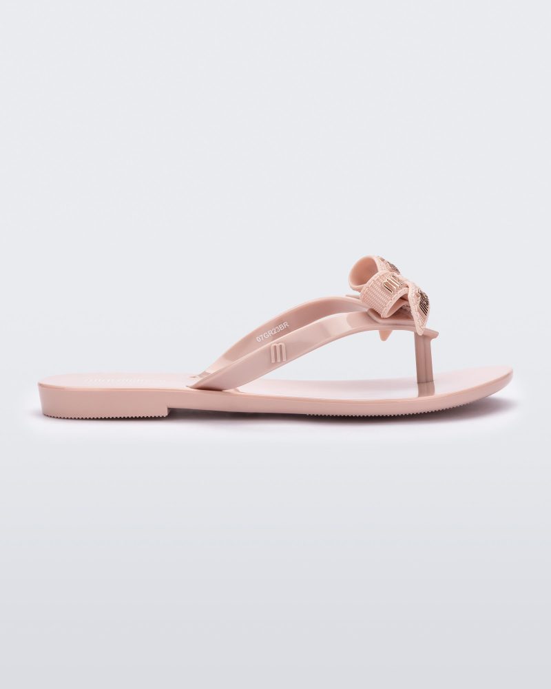 Side view of a light pink Harmonic M Lover kids flip flop with Melissa logo on bow