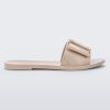 An outter side view of a Beige Melissa Babe slide with a buckle like bow detail on the front strap.