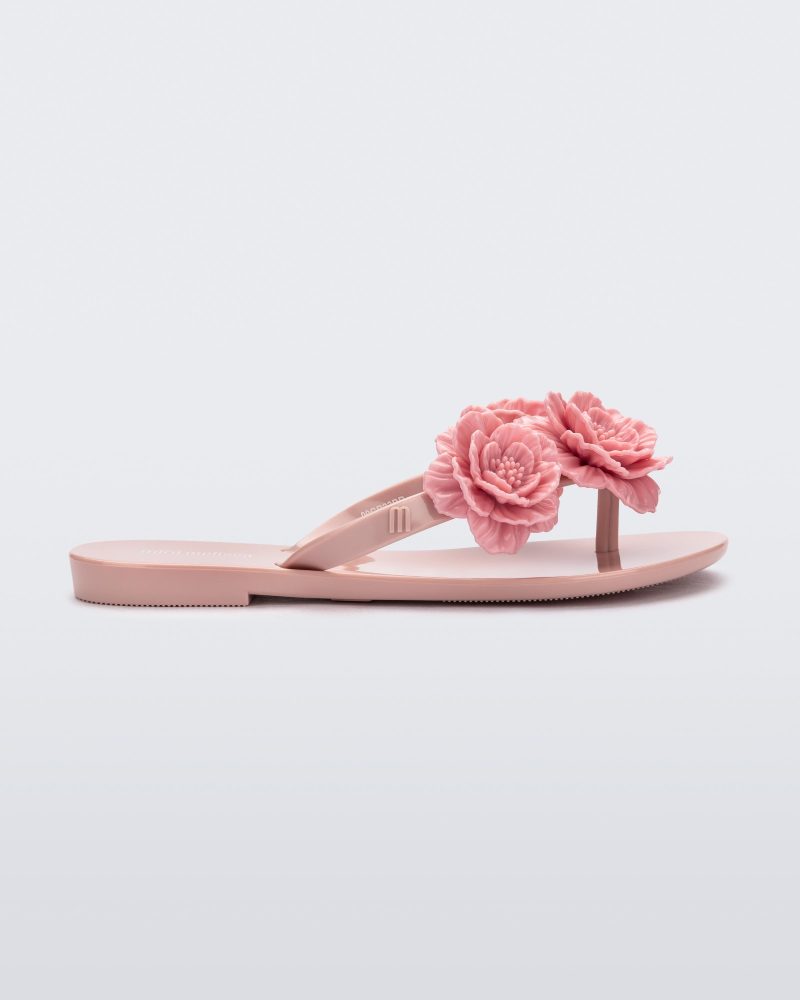 Side view of a pink Harmonic Springtime kids flip flop with three pink flowers.