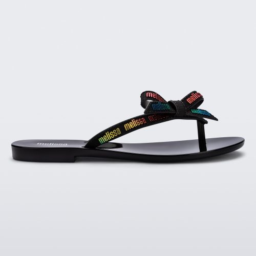 Side view of a black Harmonic M Lover adult flip flop with rainbow Melissa logo on strap