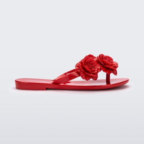 Side view of a red Harmonic Springtime kids flip flop with three red flowers.