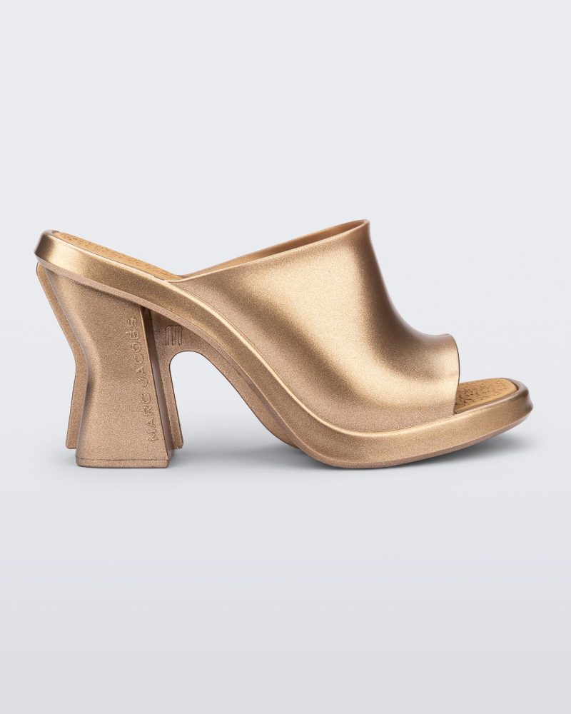 Side view of a gold Mule + Marc Jacobs heel