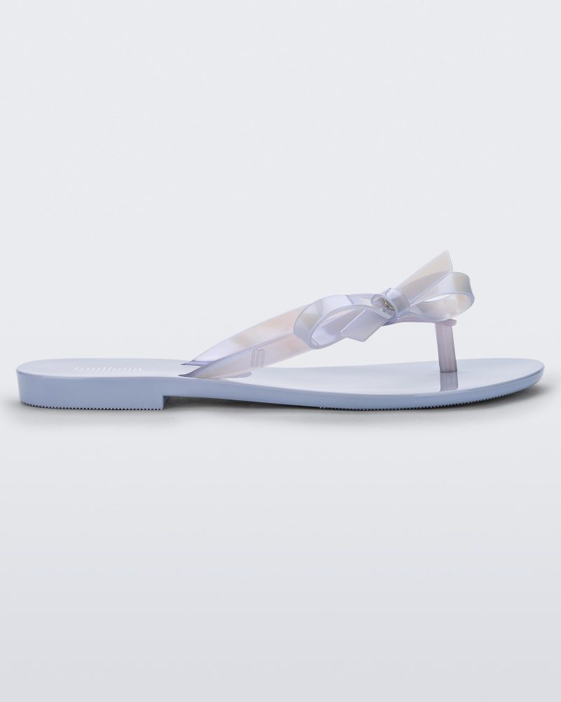 Side view of a Lilac/Pearly blue Melissa Harmonic Sweet flip flop with a lilac/pearly blue sole, straps and bow on top.