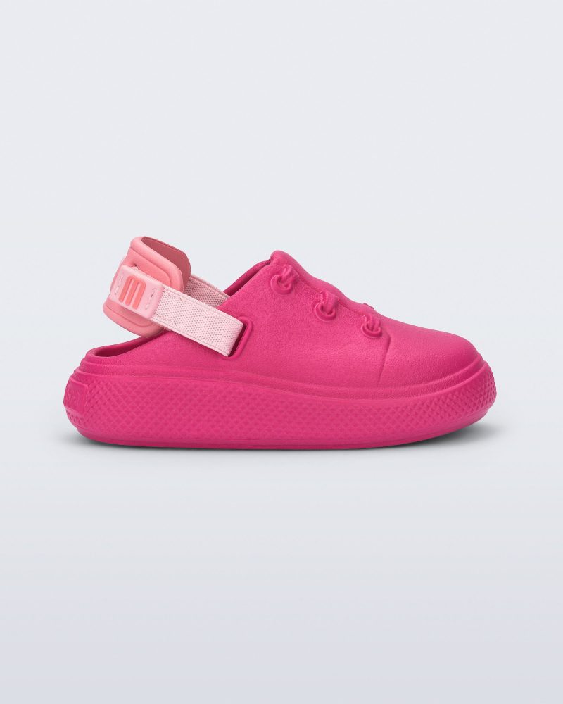 Side view of a pink with back strap Charlie baby sneaker