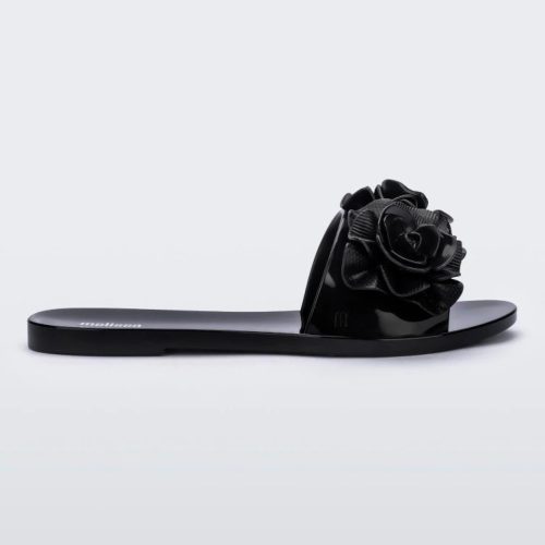 Side view of a black Melissa Babe Garden slide with two flowers on the front strap.