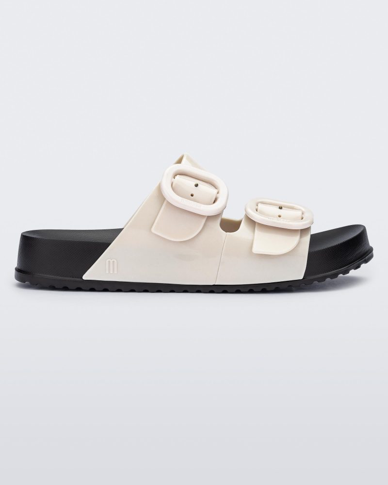 Side view of a black sole and beige upper Cozy slide