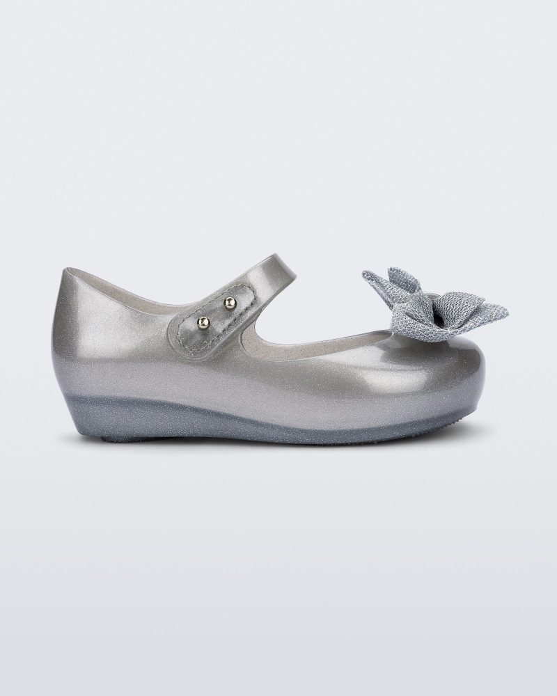 Side view of a pearly silver Ultragirl Sweet baby ballerina flat with bow