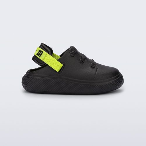 Side view of a black with green back strap Charlie baby sneaker