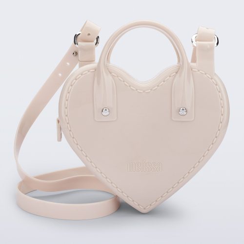 Front view of a beige Heartbeat bag with small handles and longer strap.