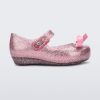 Side view of a Glitter Pink Mini Melissa Ultragirl Bow flat with a pink glitter base, top strap and pink bow on the toe.