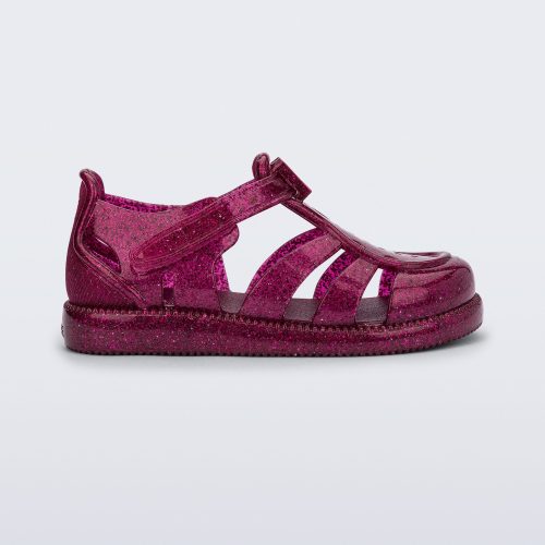 Side view of a glitter pink baby Hip Daydream sandal