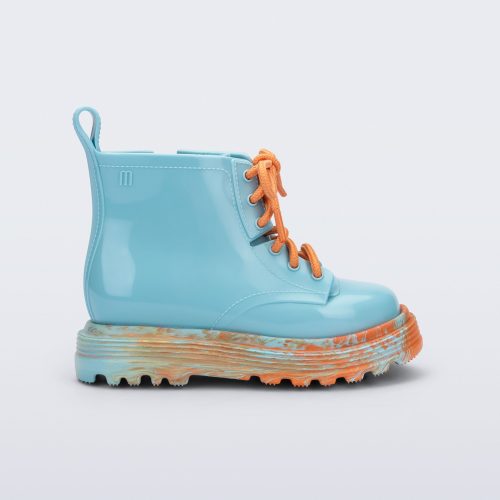 Side view of a blue Coturno baby boot with orange laces.