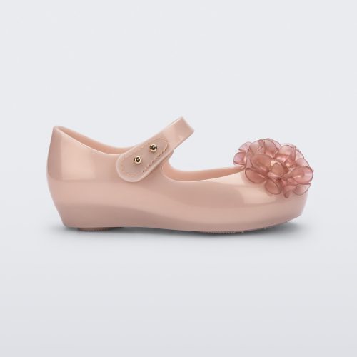 Side view of a pearly pink Ultragirl Springtime baby flat with two clear pink flowers and peep toe.