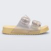 Side view of a pearly yellow Mini Melissa Cozy slide with two front straps with buckle details