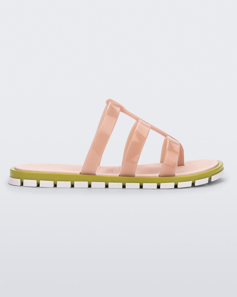 Side view of a pink Path adult sandal with  green sole