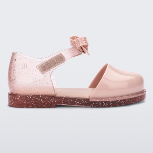 Side view of a pink Mini Melissa Amy sandal with a pink closed toe section and a back pink glitter strap with a lace like bow detail.